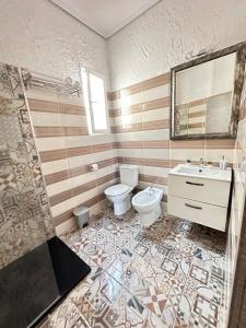 ein Badezimmer mit einem WC, einem Waschbecken und einem Spiegel in der Unterkunft Flats Puente Ademuz Apartamento de 3 habitaciones in Valencia
