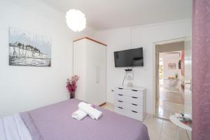 una camera con letto viola e TV di Apartment Santa a Dubrovnik