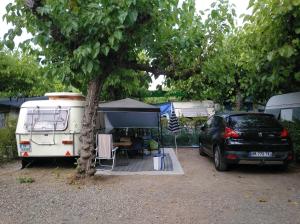 un campeggio con un'auto parcheggiata accanto a una roulotte di Camping Cambrils Caban a Cambrils