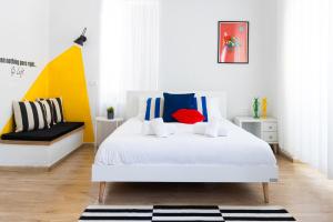a bedroom with a white bed with colorful pillows at Mamilla View- Suites & Apt Hotel in Jerusalem