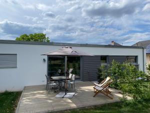 a patio with a table and chairs and an umbrella at Ferienbungalow Kampenheissji in Wiltingen