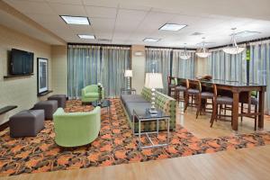 a living room with a piano and a dining room at Hampton Inn Blytheville in Blytheville