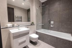a bathroom with a sink and a toilet and a bath tub at Premier London Apartments Near Camden markets & very close to tube stations by Belvilla in London