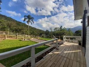 a wooden deck with a view of a mountain at Tiny House Canjerana- Morro do Eurico - Praia Grande-SC in Praia Grande
