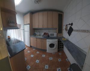 eine Küche mit Waschmaschine und Mikrowelle in der Unterkunft Mallona in Pedro Rodríguez + 8 Fotos