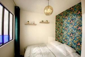 una camera da letto con un grande dipinto sul muro di Appartement avec balcon Le nid doré - PLACE MORNY a Deauville