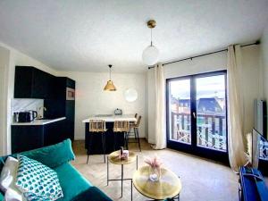 un soggiorno con divano verde e tavolo di Appartement avec balcon Le nid doré - PLACE MORNY a Deauville
