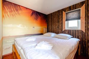 una camera con due letti e un dipinto sul muro di The Happy Hippy a Zandvoort