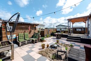 un cortile posteriore con patio e altalena di The Happy Hippy a Zandvoort