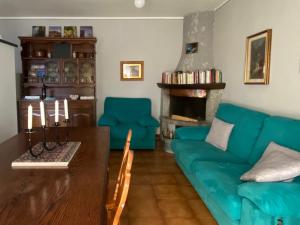- un salon avec un canapé bleu et une table dans l'établissement Dagli Olivari - Casa Ale, à Gromo