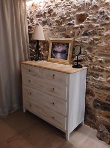 une commode avec une photo et une lampe sur elle dans l'établissement Angel's Suites, à Samos