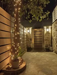 un patio con un árbol con luces encendidas en Angel's Suites en Samos