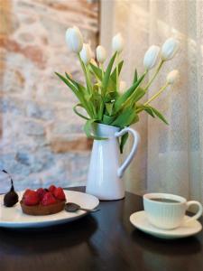 a table with a vase of flowers and a cup of coffee at Angel's Suites in Samos