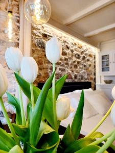 wazon z białymi tulipanami w pokoju w obiekcie Angel's Suites w mieście Samos
