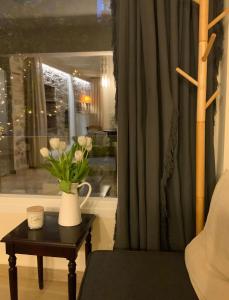 a vase of flowers on a table next to a window at Angel's Suites in Samos