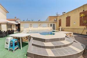 un patio trasero con piscina, mesa y sillas en Zen Village Azul, en Fernao Ferro