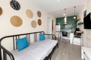 een kleine kamer met een bed en een keuken bij Zen Village Azul in Fernao Ferro