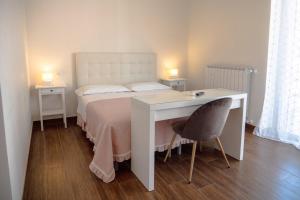 テルモリにあるb&b Da Morenaのベッドルーム1室(白いベッド1台、デスク、椅子付)