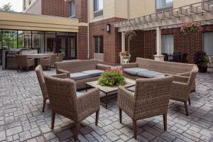 patio z wiklinowymi krzesłami i stołem z kwiatami w obiekcie Homewood Suites by Hilton Orland Park w mieście Orland Park