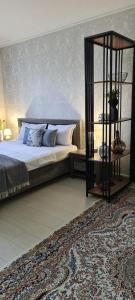 a bedroom with a large bed and a book shelf at BAYHOUSE - Апартаменты в ЖК Уш Сункар in Almaty