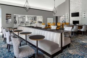 um restaurante com um bar com mesas e cadeiras em Homewood Suites by Hilton Orland Park em Orland Park