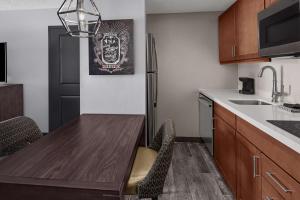 cocina con mesa de madera y nevera en Homewood Suites by Hilton Orland Park, en Orland Park