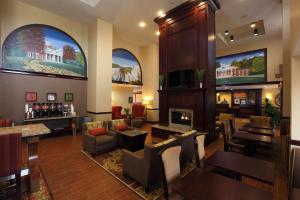 um átrio do hotel com lareira e mesas e cadeiras em Hampton Inn & Suites Charlottesville at the University em Charlottesville