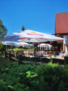 un restaurante con sombrillas y mesas blancas en Stahlecker Hof, en Lichtenstein