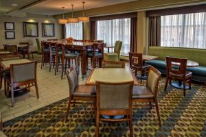 a dining room with tables and chairs and windows at Hampton Inn Charlottesville in Charlottesville