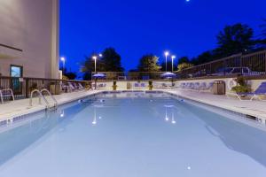 una piscina por la noche con luces en un hotel en Hampton Inn Charlottesville en Charlottesville