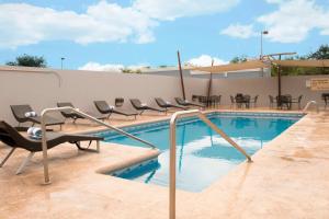 - une piscine avec des chaises et une table dans l'établissement Hampton Inn by Hilton Ciudad Victoria, à Ciudad Victoria