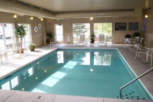 ein großer Pool in einem Hotel mit Tischen und Stühlen in der Unterkunft Hampton Inn Cedar City in Cedar City