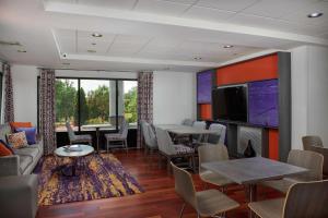 a living room with a couch and tables and chairs at Hampton Inn Clemson in Clemson
