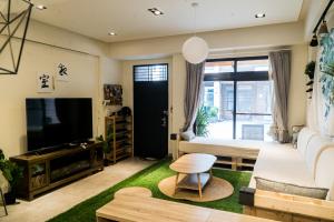 - un salon avec un lit, une télévision et un canapé dans l'établissement 礁溪夜室, à Jiaoxi