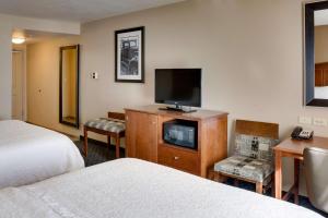 a hotel room with two beds and a flat screen tv at Hampton Inn Chickasha in Chickasha