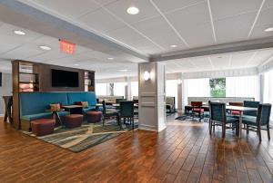 a lobby with tables and chairs and a tv at Hampton Inn Patriots Point in Charleston