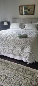 un grande letto bianco con un cuscino verde sopra di Fiddlers Cottage a Kesh