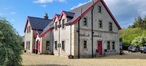 un gran edificio blanco con techo rojo en Fiddlers Cottage, en Kesh