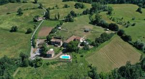 una vista aerea di una tenuta con una casa e una piscina di Agriturismo Il Salice a Tizzano Val Parma