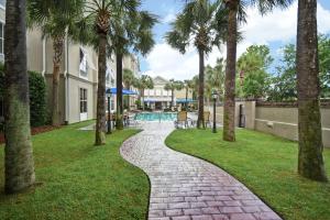 una pasarela a través de un patio con palmeras en Hampton Inn & Suites Charleston-West Ashley en Charleston