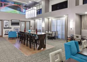 a dining room and living room with a table and chairs at Hampton Inn & Suites Cedar Rapids in Cedar Rapids