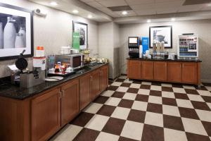 ein Café mit einer Theke und einem karierten Boden in der Unterkunft Hampton Inn & Suites Cedar Rapids in Cedar Rapids