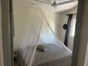 łóżko z moskitierą w pokoju w obiekcie Villa Aquarêve w mieście Saly Portudal