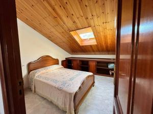 1 dormitorio con cama y techo de madera en Ático completo de 3 habitaciones en O Barqueiro, en O Barqueiro