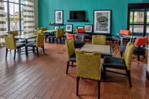uma sala de jantar com mesas e cadeiras e uma parede verde em Hampton Inn & Suites Clarksville em Clarksville