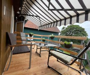 un patio avec des chaises, une table et un parasol dans l'établissement Ferienwohnung Hohensee 1.OG, à Clausthal-Zellerfeld