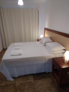 ein Schlafzimmer mit einem großen weißen Bett mit weißen Kissen in der Unterkunft Corais de Flecheiras in Trairi