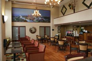 a restaurant with tables and chairs and a large screen at Hampton Inn & Suites Cleveland-Mentor in Mentor
