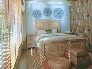 ein Schlafzimmer mit einem Bett und einer Ottomane in der Unterkunft Roaming Cloud Sun Moon Lake B&B in Yuchi