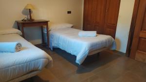 Zimmer mit 2 Betten und einem Tisch mit einer Lampe in der Unterkunft Casa Castillo in Torres